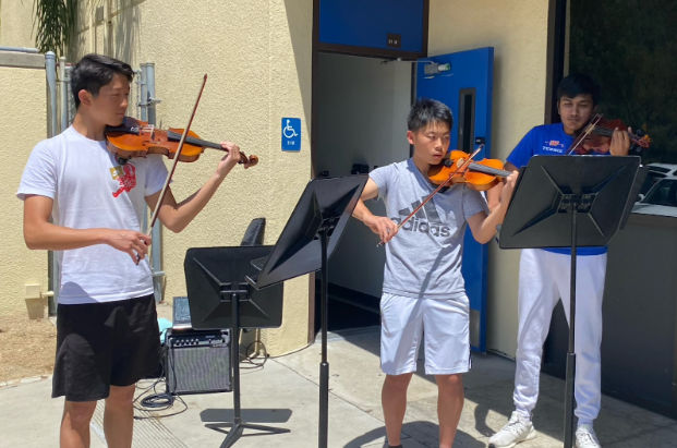 PLAYING THE CLASSICS: Bryan Huang ‘24 (left), Matthew Zhang ‘24 (middle) and Tarun Subramanian ‘24 (right) perform Bach’s double violin concerto on April 27 during lunch. The group of musicians plans to perform more in the future.