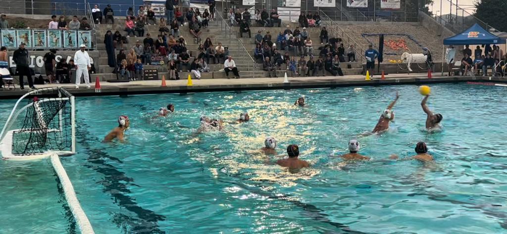 WHS varsity water polo plays Oaks Christian High School at home on Oct. 25. Benet Fujikake ‘26 shot the ball while being pressed by an Oaks defender, eventually scoring for the team. 