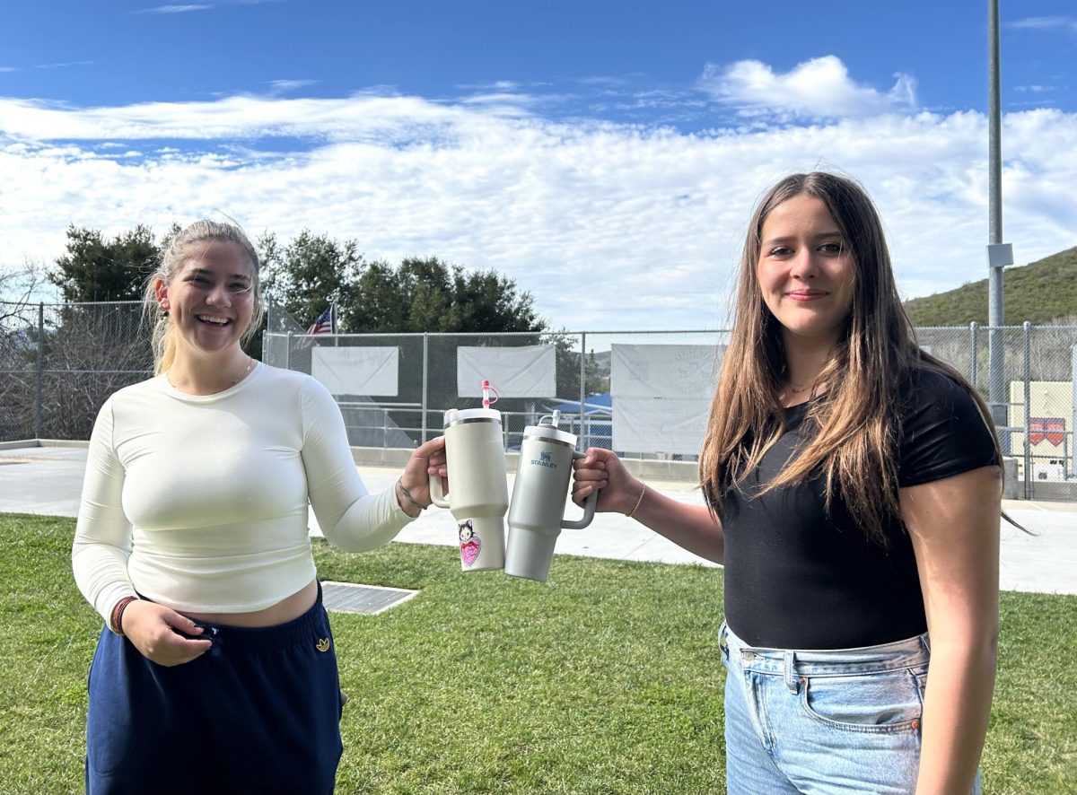 STANLEY CUPS CREATE BONDS:  Breanna Zide ‘24 and Tati Zide ‘27 clink their Stanley Quenchers, adorned with straw covers and stickers.